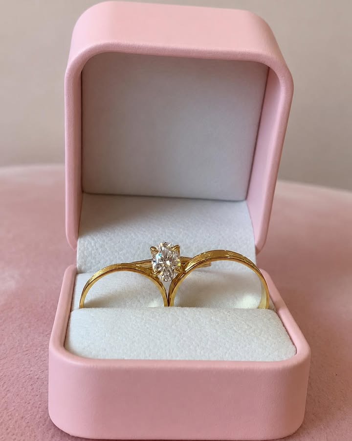 The couple's wedding rings in a blush ring box